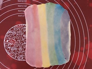 8、彩虹蛋黄酥,压扁，用擀面杖上下擀开。注意厚度保持一致。多余的白边切掉，每个颜色的宽度尽量保持相同