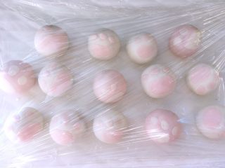 18、猫爪汤圆,同样的方法做好其他面团,白色面团配粉色的猫爪,粉色的面团配白色的猫爪,防止面团表面干裂,做好的猫爪汤圆要盖上保鲜膜