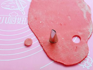 11、预热元宵节～猪圆玉润芝麻汤圆,现在准备做猪鼻子和耳朵，红色面团用擀面杖擀薄，再用裱花嘴压出圆形。