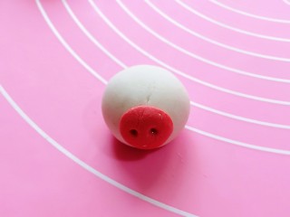 16、预热元宵节～猪圆玉润芝麻汤圆,取一个包好的汤圆，把猪鼻子沾在汤圆上。(可以涂一点水沾猪鼻子)
