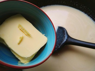 4、桃山皮月饼,放不粘锅里中小火加热，不停搅拌，然后加入130克黄油