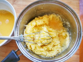 7、清新甜美的蜂蜜牛油果泡芙,将蛋液分三次倒入面团里，边倒边搅拌，至蛋液与面团融合，