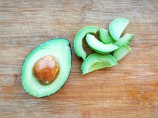 14、清新甜美的蜂蜜牛油果泡芙,在烤箱工作的过程中，我们来处理牛油果，牛油果沿着核中心切开，去皮，切成片，