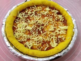 9、南瓜虾仁培根披萨,取出抹批萨酱，薄薄的撒一层奶酪