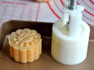 21、金沙奶黄月饼,将包好的月饼放入50克的月饼模中，轻轻一压，月饼的雏形就有了。