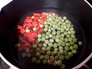 2、炒饭秀+辣白菜炒饭,将胡萝卜切小丁和豌豆一起下锅煮熟。