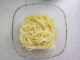 6、芝士彩蔬意面,意面煮好,捞起来滤干水分,加入适量的油,搅拌一下,放一旁待用