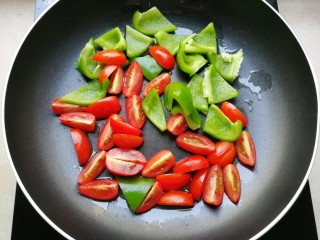 8、芝士彩蔬意面,放入小番茄和青椒,翻炒一下