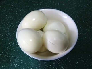 3、照晓鸡腿烩鸡蛋,剥去蛋壳，再用小刀在四周轻划几刀便于入味