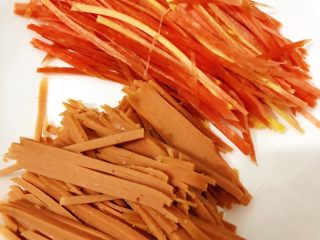 4、香酥黑椒手抓饼,将洗净、削皮的半截胡萝卜????切丝，3分之一的火腿切丝备用。（注：不一定非要选用胡萝卜、可选黄瓜????，当然也可以都加，根据个人喜好选取食材；因个人喜好，所以选取了胡萝卜）。