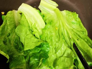 8、香酥黑椒手抓饼,将煎制好的加蛋饼皮盛起装盘备用，同锅将洗净备好的3片生菜叶放入无油锅中小火煸炒10秒捞起（为了不让卷制时有蓬松感）