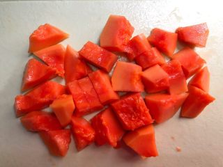 4、木瓜桃胶牛奶,木瓜冲洗一下,对半切开,把里面的籽掏掉,再把外皮刮掉,切成小块待用。