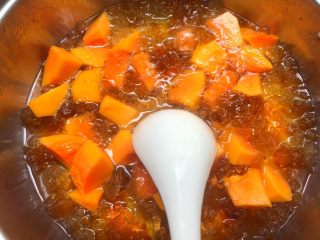 6、木瓜桃胶牛奶,把切好的木瓜放入,搅拌均匀煮2分钟。