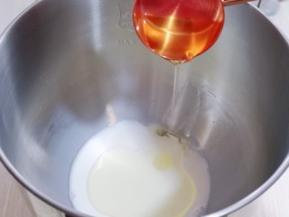 2、日式炼乳蔓越莓面包,首先将液体加入厨师机桶中。（牛奶，玉米油）