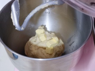 4、日式炼乳蔓越莓面包,启动厨师机，1档揉面10分钟，10分钟后面团处于扩展阶段！这时加入室温软化的黄油！再次启动厨师机2档揉面约为20分钟！