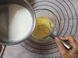 4、日式香草卡仕达,缓缓的倒入蛋黄糊中,一边倒一边搅拌