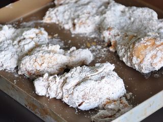 21、香酥脆皮炸鸡,将裹好粉的鸡块放在盘中备用。