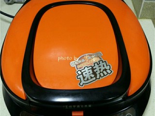 9、西红柿鸡蛋披萨,打开电饼铛的上、下开关，启动“预热”程序；盖子放下来，但不要盖严，以免芝士粘在上烤盘上；