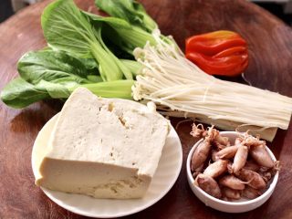 1、金针菇豆腐鱿鱼煲,首先备齐所有的食材，小鱿鱼我是用的晒干的，提前用温水浸泡。