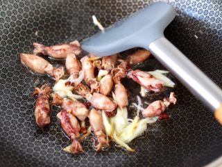 5、金针菇豆腐鱿鱼煲,另起锅烧热后，倒入花生油烧热，先小火慢慢炸香花椒，再大火爆香葱姜，把小鱿鱼放入锅中小火慢慢煸炒片刻。