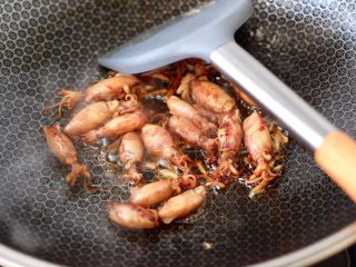 7、金针菇豆腐鱿鱼煲,大火继续把小鱿鱼翻炒均匀。