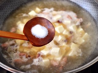 8、金针菇豆腐鱿鱼煲,锅中倒入适量的清水烧开后，放入焯水的豆腐，根据个人口味加入适量的盐调味。