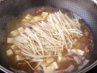 9、金针菇豆腐鱿鱼煲,大火烧开后炖煮5分钟左右，加入金针菇。