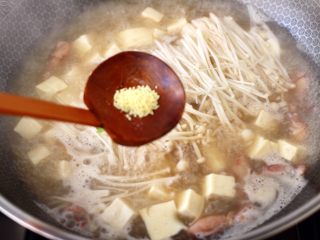 10、金针菇豆腐鱿鱼煲,继续大火煮1分钟左右，放入鸡精增加口感。