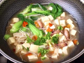13、金针菇豆腐鱿鱼煲,炖煮至青菜断生变色时关火，撒上香菜段即可。