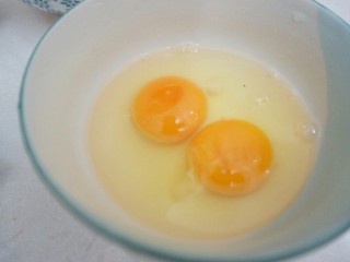 3、甜酒冲蛋配汤圆,碗内两个鸡蛋,稍微打散之后(不充分打散就可以吃到有白色有黄色的蛋花);