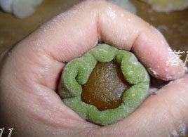 11、冰皮月饼,用虎口位置慢慢收口，稍按扁，滚上一些手粉