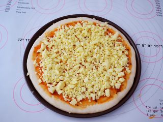 8、杂蔬火腿肠披萨,先撒上一层芝士碎