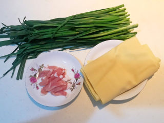 1、韭菜炒千张,准备食材：韭菜，干豆腐，提前把肉片切成小片