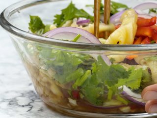 5、泰式无骨柠檬凤爪,酸辣汁倒入鸡爪中，加入红椒丝、黄瓜丝、洋葱丝、香菜碎、葱花，搅拌均匀