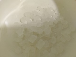 9、荔枝罐头,将冰糖倒入到水里，开大火将冰糖煮化。