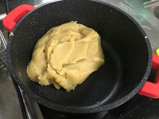 4、广式莲蓉月饼（自制内馅）,馅料形成一整块的状态，用锅铲翻动莲蓉馅，呈现整块挪动的状态