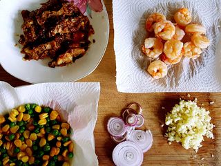 7、鸡肉海鲜披萨,7．接下来准备我们所需的配料，将青豆与玉米粒煮熟，把表面的水用厨房纸擦干，黑虎虾仁汆烫熟，洋葱圈尽量切得细一点，我还加了昨天做的照烧鸡腿。当