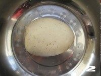 2、【花边培根披萨】换着花样吃披萨,分次加入温水或牛奶（约90克）和成光滑的面团，盖上保鲜膜开始饧发。（可用烤箱发酵功能加快发酵）