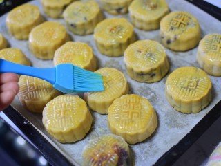 18、广式豆沙蛋黄月饼,取出来，刷一层薄薄的蛋黄液，再放回烤箱烤18分钟左右，晾凉即可食用，回油后味道更佳