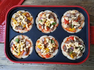 18、至尊牛肉小披萨,铺上一层炒好的牛肉和配菜，根据个人口味撒上适量的奶酪碎。