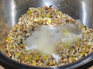 5、五仁月饼,把材料中大些的材料切碎，全部倒入盆里，在倒日准备好的白糖，植物油，白酒，水搅拌均匀