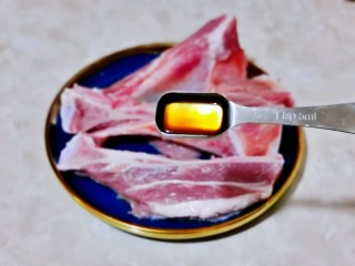4、蒜香烤排骨,加入两勺料酒。