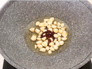 5、家常烧草鱼,炒锅烧热后加入大豆色拉油，油烧热后加入蒜瓣和花椒粒，炒出香味