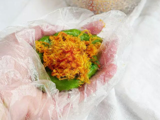 11、咸蛋黄肉松青团,戴上一次性手套，取一小份青团，搓圆后压成饼状，可以事先抹点食用油防粘，裹入咸蛋黄肉松。