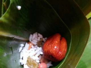 7、蜜枣什锦粽子,先放入少许粽米，然后放1颗蜜枣。