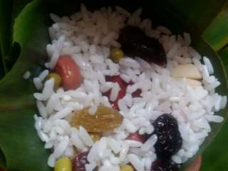 9、蜜枣什锦粽子,再覆盖1层粽米，至到把漏斗填满。