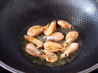 5、芹菜香菇北极虾小炒,另起锅烧热后倒入花生油烧热，小火先把北极虾煎出虾油，盛出备用。