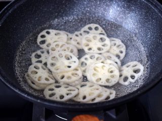 4、荷塘月色小炒,锅中倒入适量的清水煮沸后，把藕片进行焯水，看见藕片变得透明的时候，捞出过冷水后沥干水分。
