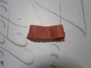 13、卡通小熊萝卜糕便当盒「14」,将火腿肠折叠起来，用到切出条纹，不要切断。