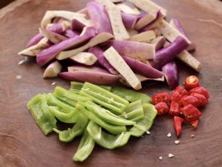 4、海虾肉片辣炒茄条,把茄子用刀切成条，青椒切条，红尖椒切丁。